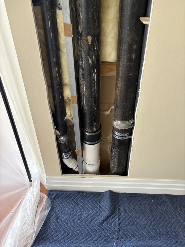 Old leaking kitchen stack exposed inside an opened wall at a Sarasota condominium