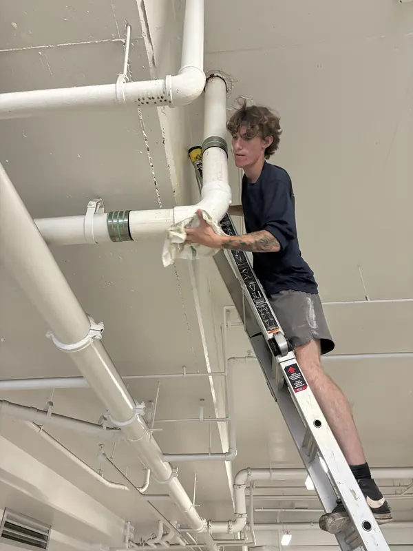 Greater Bay Plumbing technician finishing the new kitchen stack in a Sarasota condominium parking garage