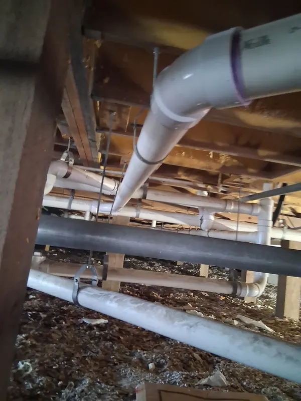 New PVC drain piping installed under a restaurant building in Nokomis during a plumbing rough-in